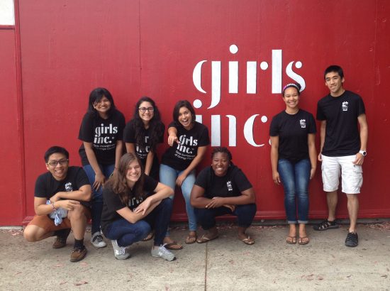 DukeEngage students posing in front of a sign for Girls Inc
