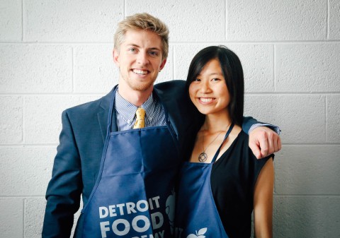 Two students smiling in aprons