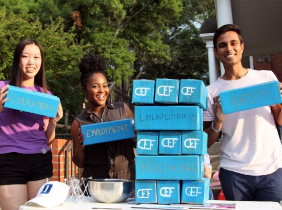 three young people holding blocks with finance-related words