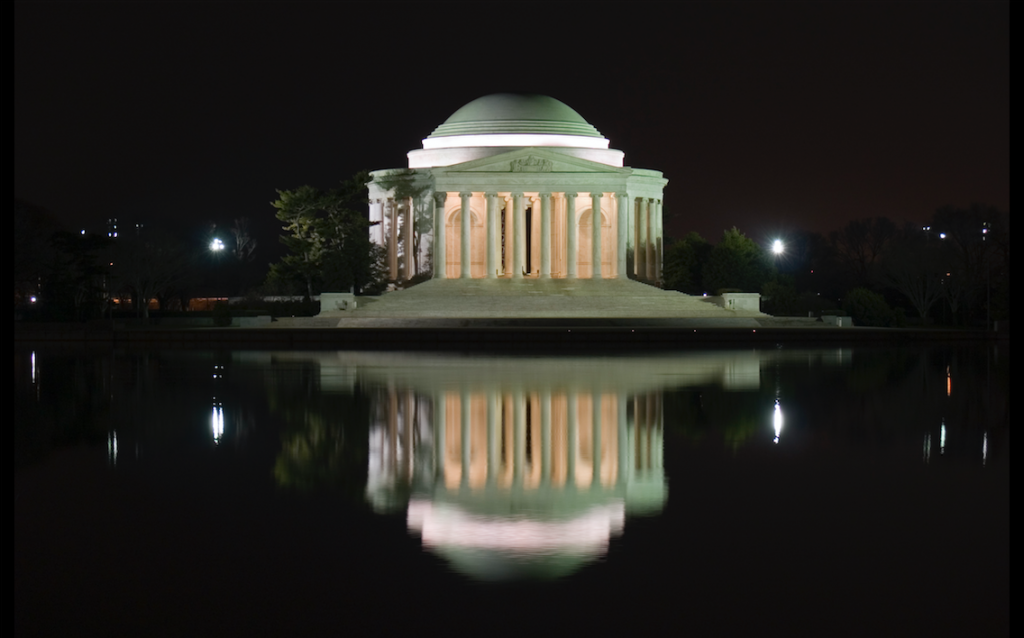 White marble building in front of a body of water