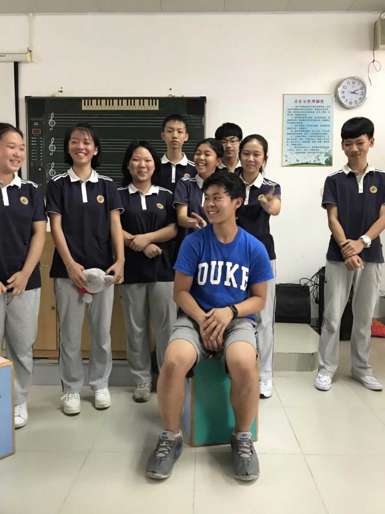 duke student surrounded by Chinese school children