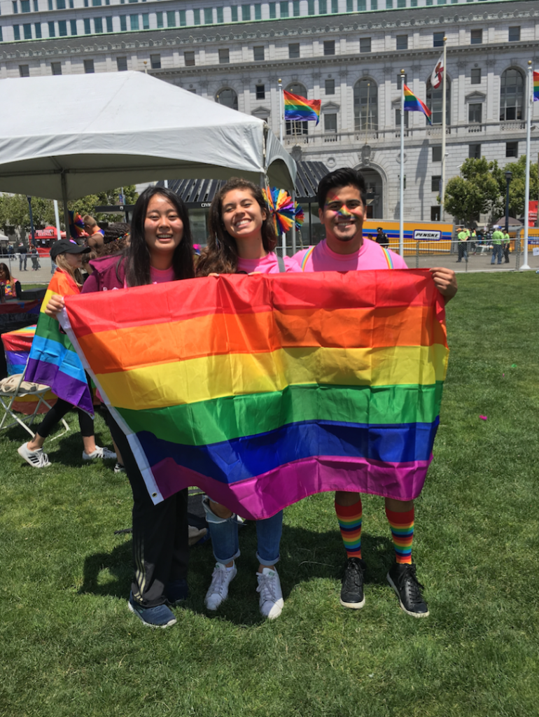 Young adults holding a Pride flag