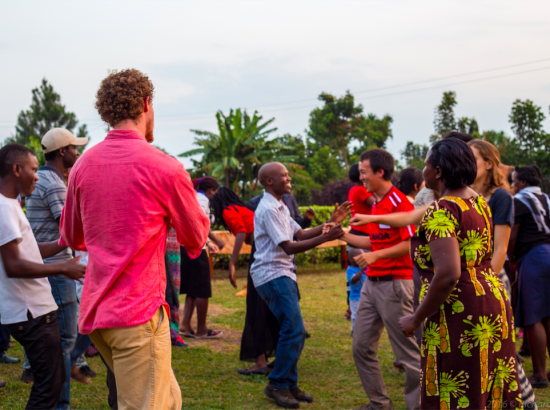 DukeEngage students and members of the community in Uganda join hands and celebrate