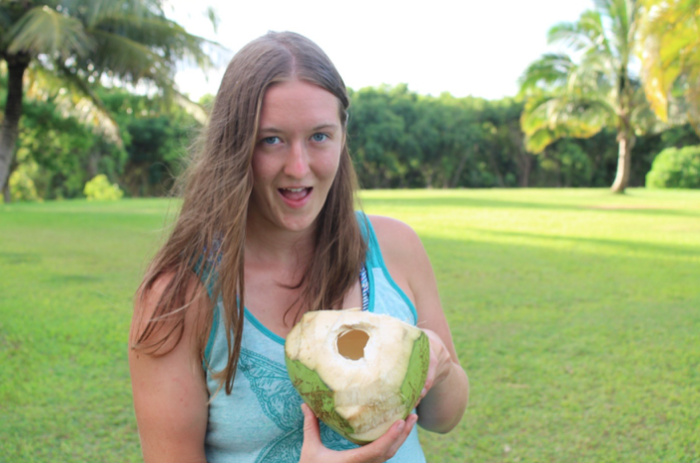 A girl posing with a green coconut