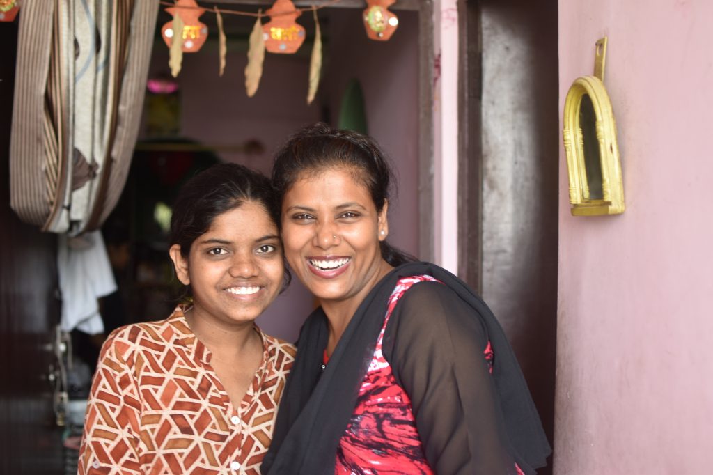 two women smiling and posing for the camera