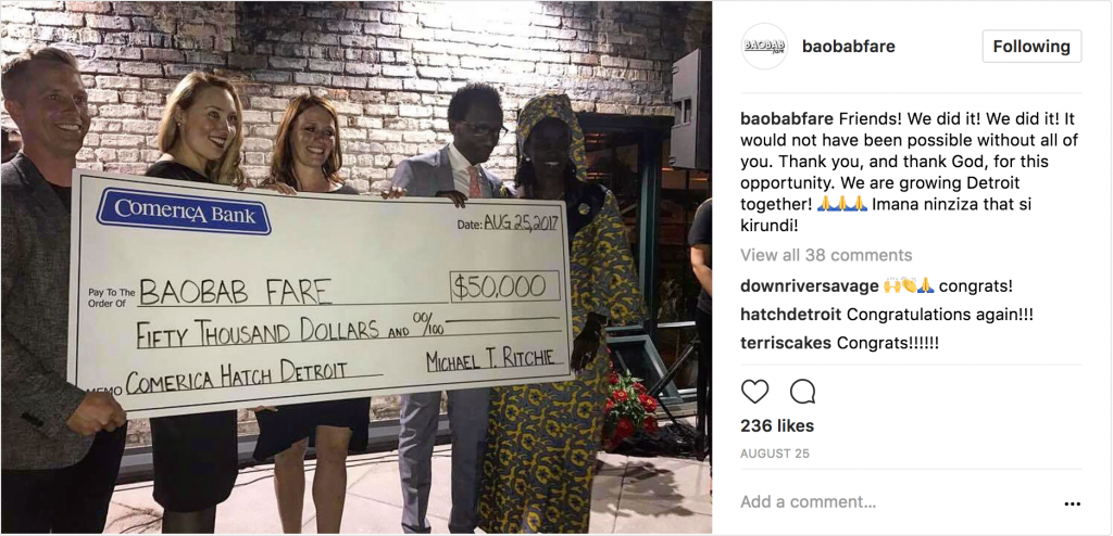 Instagram post of man holding 5 people holding large cardboard check