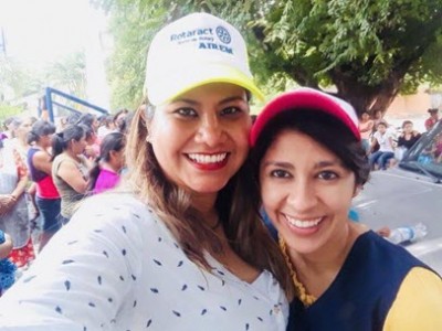 two women wearing baseball caps smiling at camera