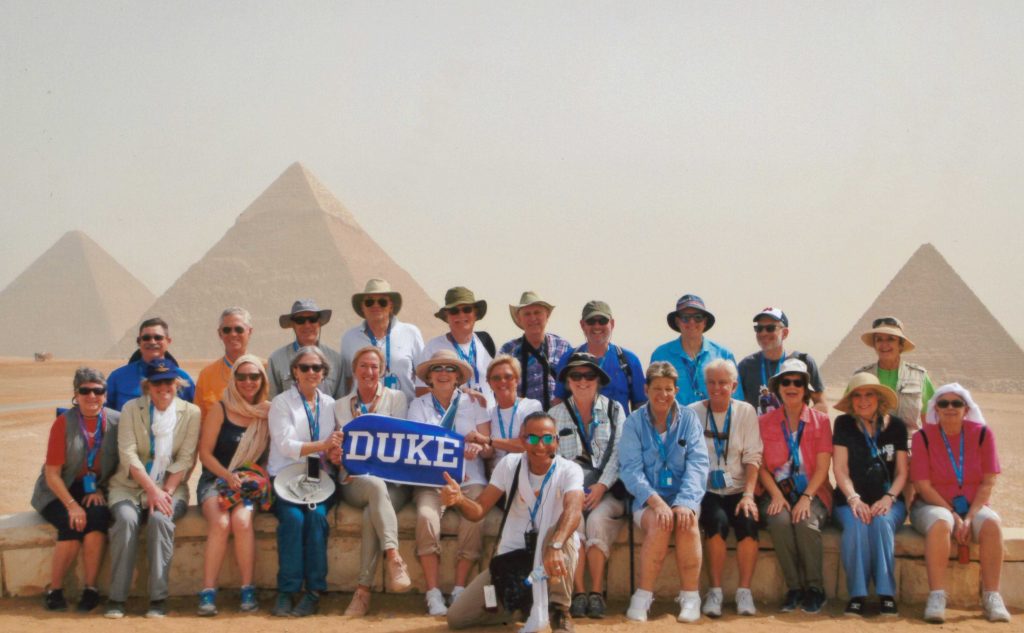 Group of people posing for photo in front of pyramids in the desert