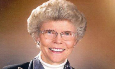 woman wearing glasses smiling at camera