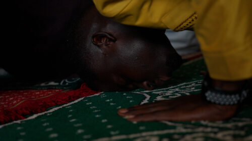 A man kneeling with his head on the floor