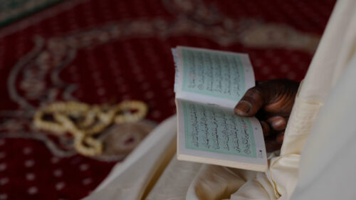 A hand holding a book of prayers