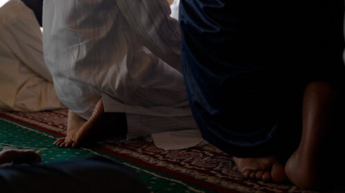 People kneeling on the floor of a mosque